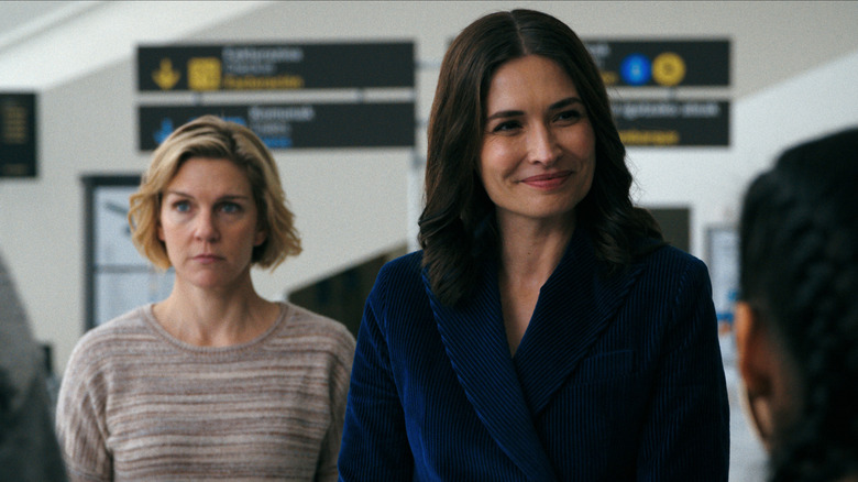 Rhea Seehorn dans le rôle de Carol Sturka et Karolina Wydra dans le rôle de Zosia se tenant côte à côte dans un aéroport de Pluribus