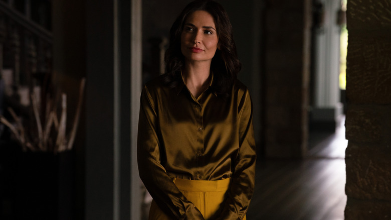 Zosia debout dans une pièce sombre regardant sur le côté sur Pluribus