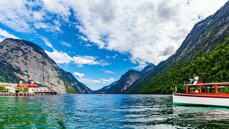 Un bateau rouge et blanc se dirige vers l'église Saint-Bartholomä sur le lac Königssee, entouré de montagnes dans le parc national de Berchtesgaden en Allemagne