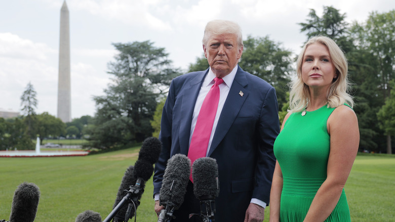 Donald Trump et Karoline Leavitt debout sur la pelouse de la Maison Blanche