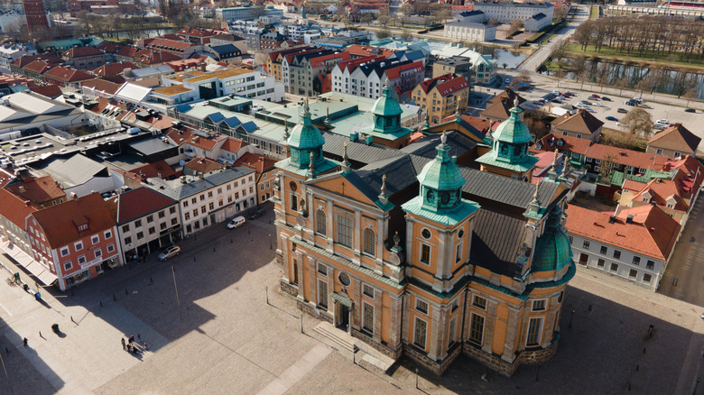 Une photo aérienne de la cathédrale jaune de Kalmar sur une place du centre-ville