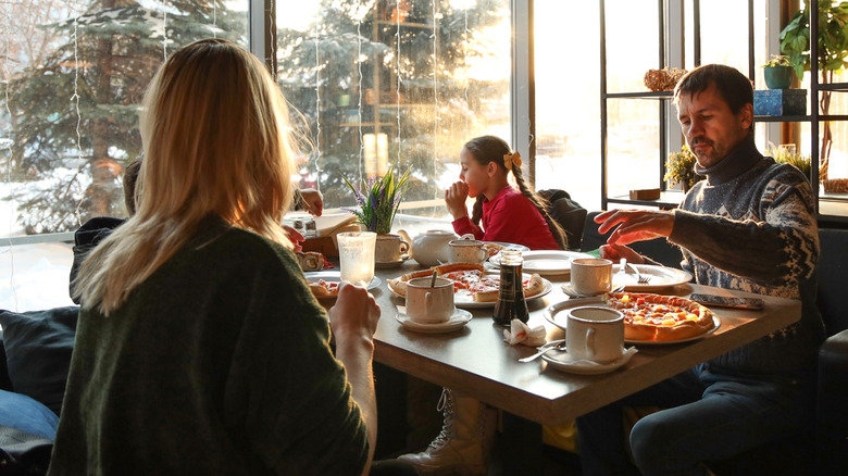 Une famille mange de la pizza dans un café