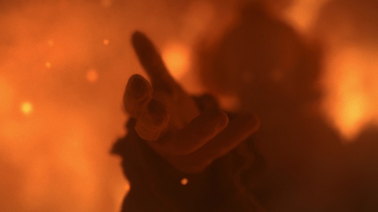 Pennywise tend la main en guise d'altriusme pendant l'incendie dans It : Welcome to Derry