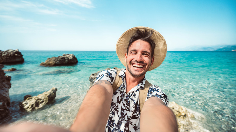 Homme heureux prenant un selfie avec un téléphone portable intelligent à l'extérieur