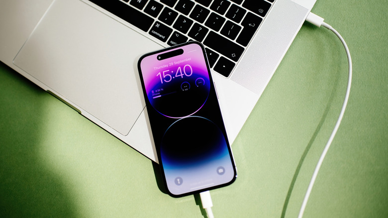 Un iPhone 15 Pro connecté à un MacBook Pro via un câble USB-C