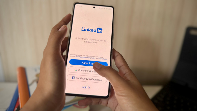 Une femme en train de se connecter ou de créer un compte sur LinkedIn sur un téléphone