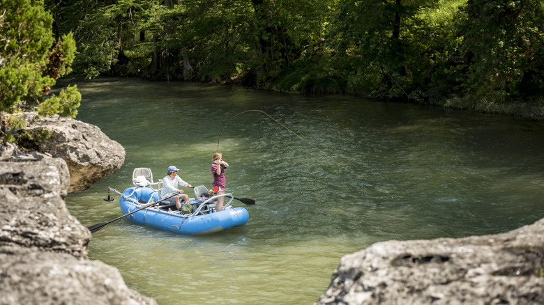 les gens pêchant en canot sur la rivière