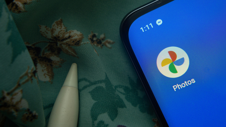 Logo Google Photos sur un smartphone avec écran bleu.