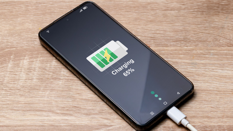 Un smartphone en charge sur une table.