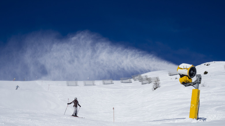 Un canon à neige produit de la neige sur une montagne