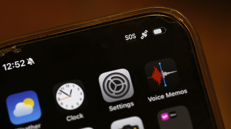 Un écran de téléphone portable affichant diverses applications avec SOS dans le coin supérieur droit
