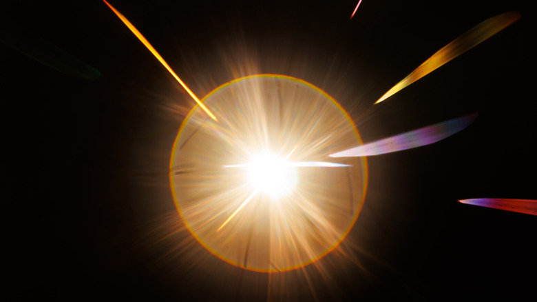 Un buste d'étoiles, le soleil capturé dans une image d'intensité lumineuse, un cercle de lumière avec des faisceaux de lumière jaillissant à des angles