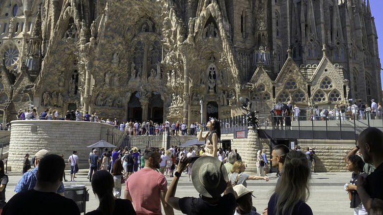 Les touristes photographient l'entrée de l'église de la Sagrada Familia à Barcelone, Espagne