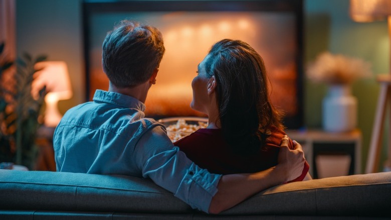 Un couple regarde la télévision sur le canapé