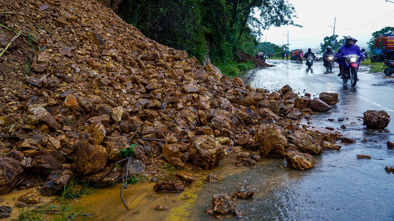 éboulement recouvrant partiellement une route trempée par la pluie