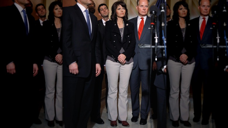 Kristi Noem, en blazer noir, chemise grise et pantalon blanc cassé, aux côtés de ses compatriotes républicains au Capitole américain en 2011