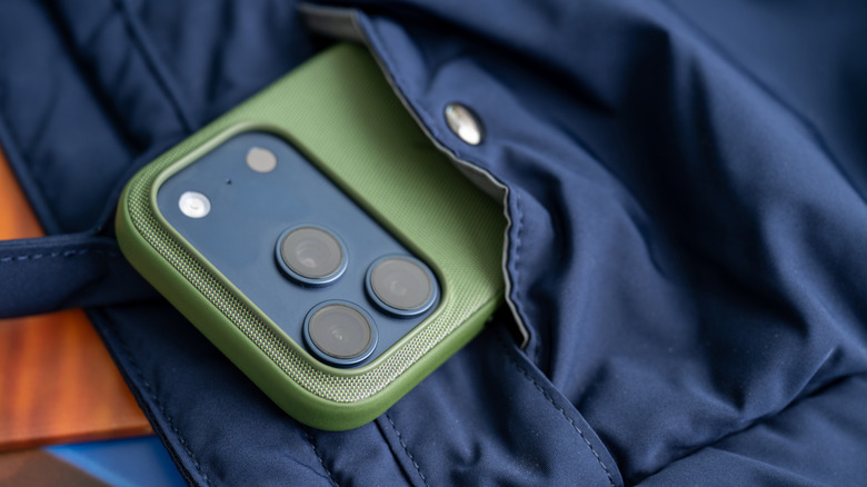 iPhone 17 Pro dans un étui TechWoven vert sortant d'une poche de sac