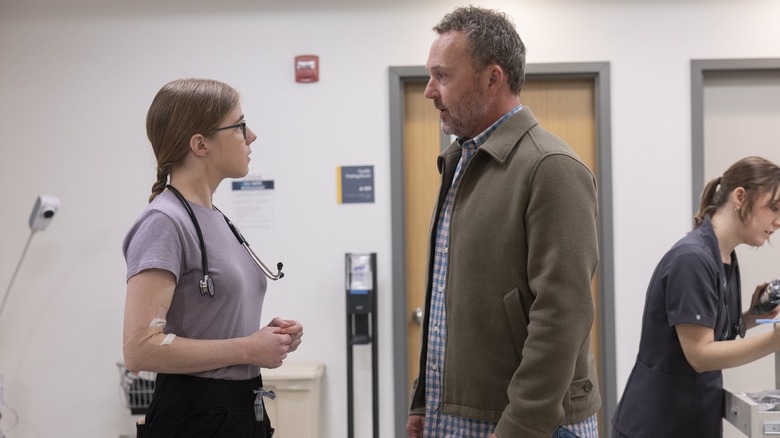 Mel parle au père d'un patient dans le couloir du Pitt