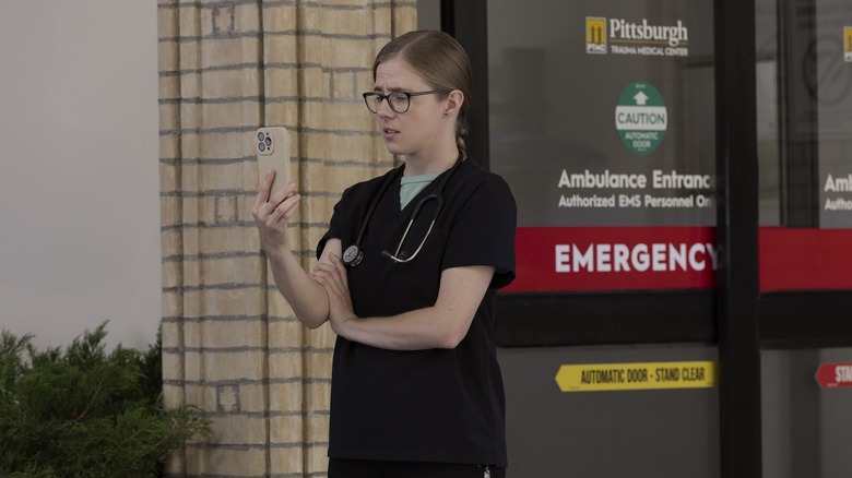 Mel regarde son téléphone dans l'infirmerie du Pitt.