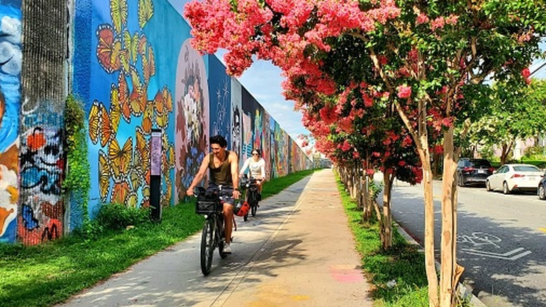 Deux cyclistes passant devant des peintures murales de rue sur la Beltline d'Atlanta.