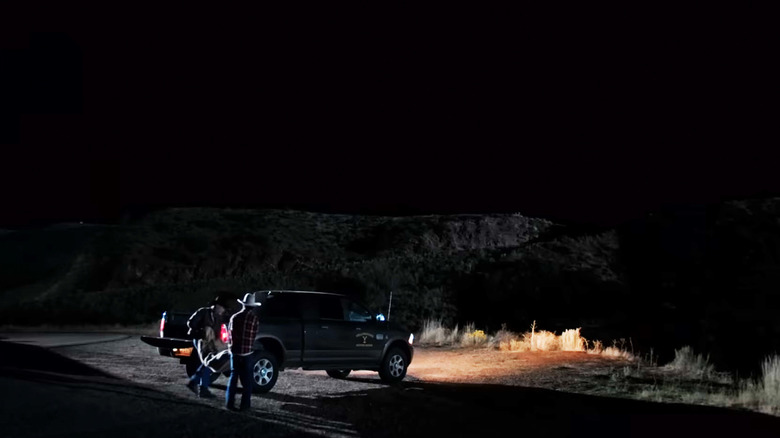 Lloyd Pierce de Forrie J. Smith et un assistant transportent un corps depuis leur camion à la gare de Yellowstone