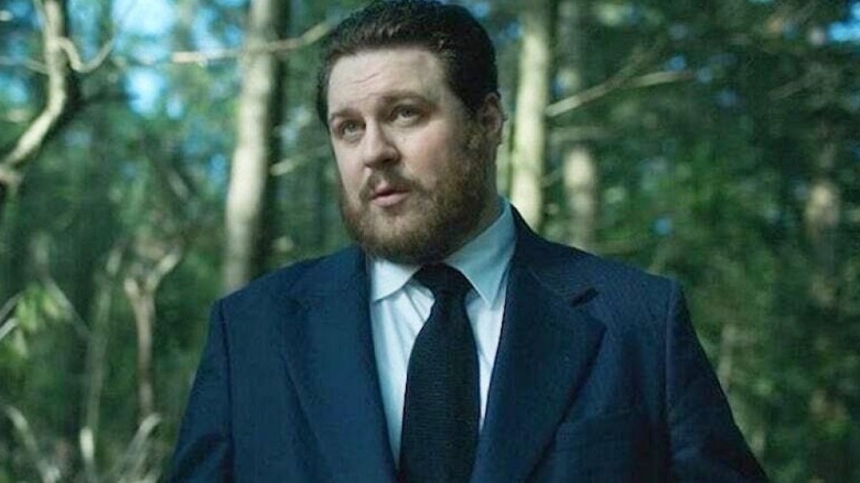 Hazel (Cameron Britton) debout dans une forêt 