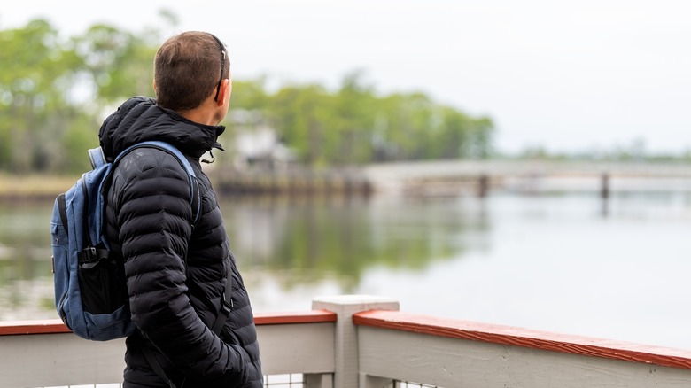 homme avec sac à dos regardant la vue du pont