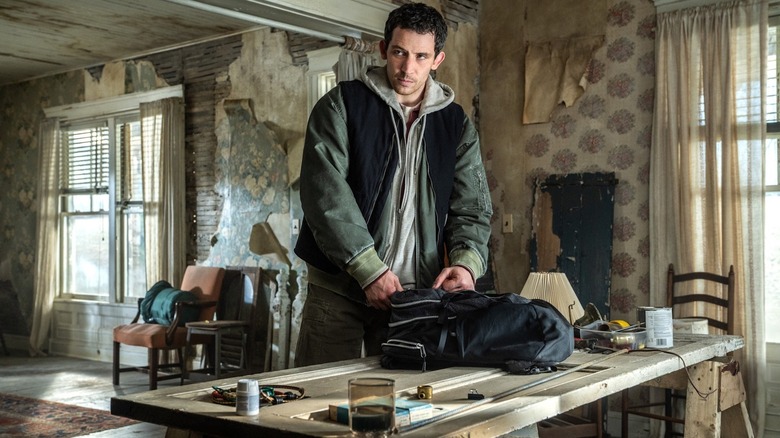 Jack O'Connell dans le rôle de Daniel Kellner trie un sac à dos sur une table de cuisine lors de la journée de divulgation