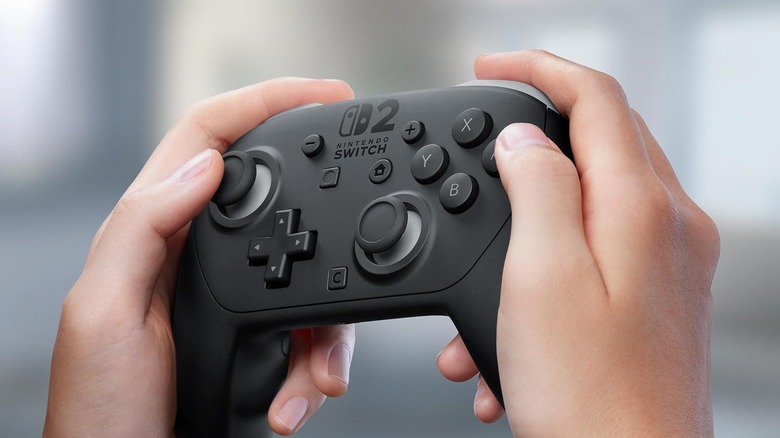 personne tenant la manette Switch 2 Pro