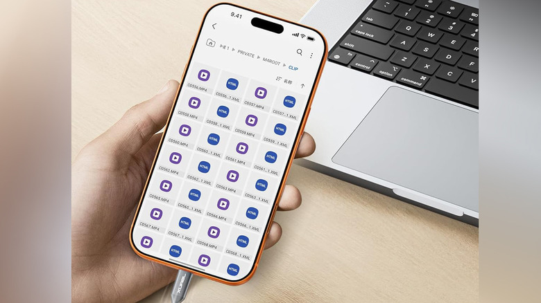 Gros plan d'une main tenant un téléphone mobile avec un adaptateur USB-OTG branché