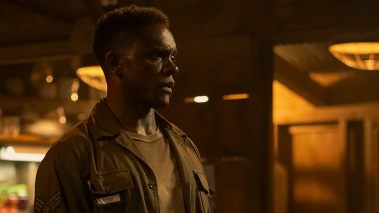 Dick Hallorann de Chris Chalk regarde à travers une pièce faiblement éclairée dans It Welcome to Derry