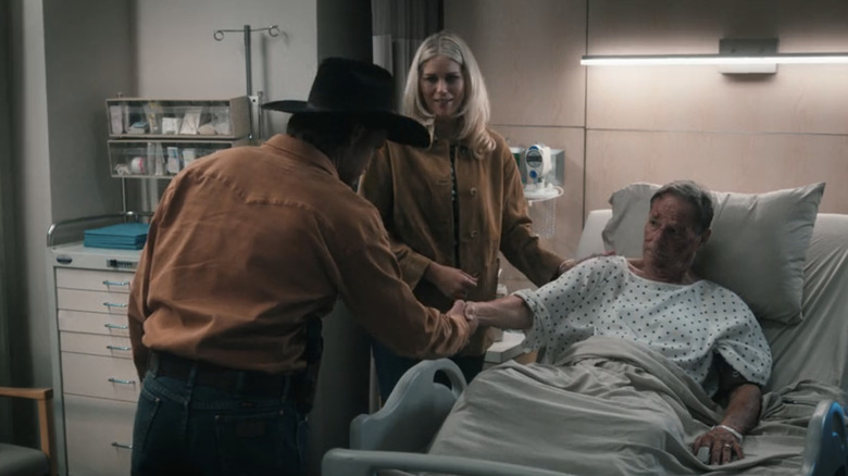 Kayce Dutton de Luke Grimes serre la main de Tom Weaver de Chris Mulkey tandis que Dolly Weaver d'Ellyn Jameson regarde dans une chambre d'hôpital dans Marshals