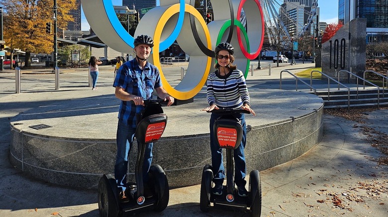 Deux pilotes de Segway devant les anneaux olympiques du Centennial Olympic Park, au centre-ville d'Atlanta.
