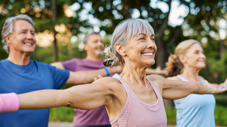 Seniors pratiquant des étirements en plein air avec de grands sourires