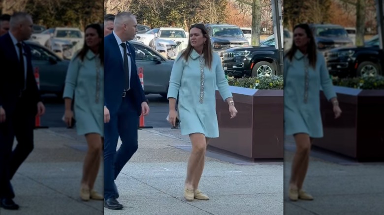Sarah Huckabee Sanders marchant dans une mini-robe bleu clair et portant des mules jaunes à mors de cheval