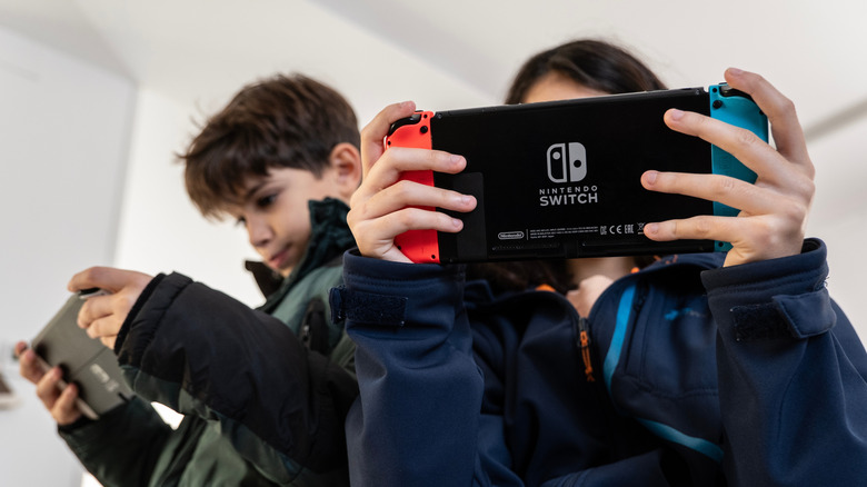 Garçon et fille jouant sur les consoles Switch