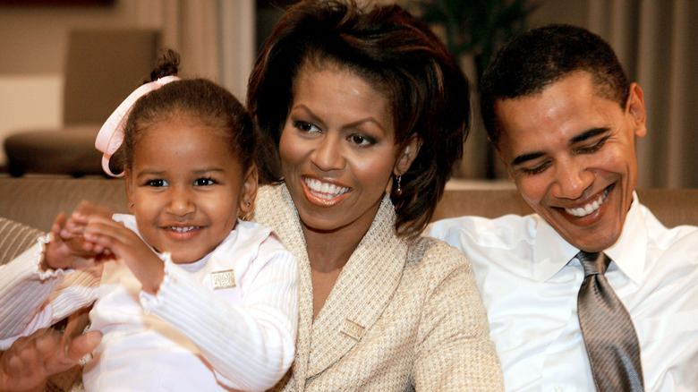 Sasha, Michelle et Barak Obama sourient l'un à côté de l'autre
