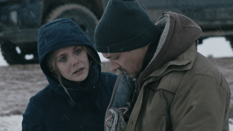 Jane Banner d'Elizabeth Olsen se trouve à côté de Cory Lambert de Jeremy Renner à l'extérieur dans un environnement enneigé à Wind River