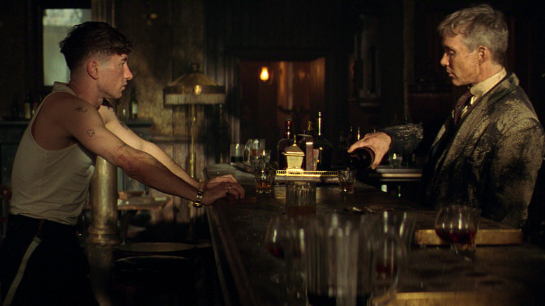 Barry Keoghan dans le rôle de Duke Shelby partageant un verre avec Cillian Murphy dans le rôle de Tommy Shelby dans un bar de Peaky Blinders : The Immortal Man