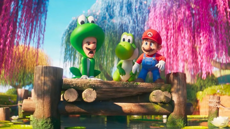 Luigi en costume de grenouille à côté de Yoshi et Mario dans The Super Mario Galaxy Movie