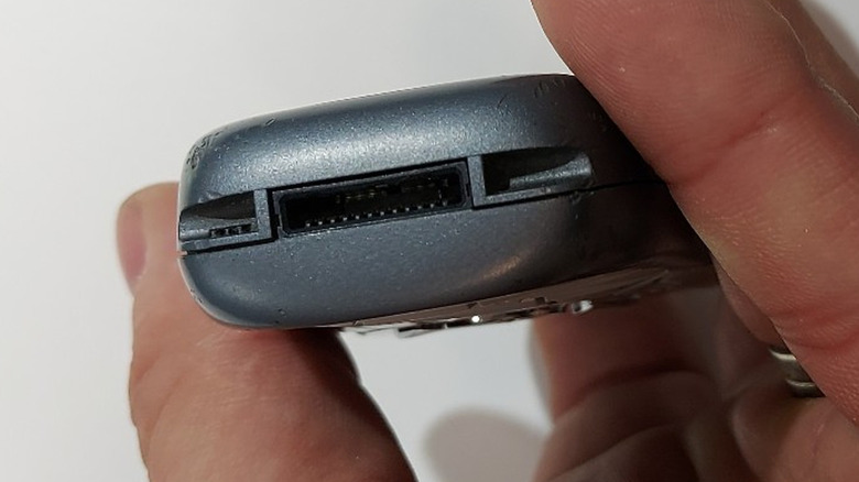 Une personne tenant un téléphone Siemens montrant un port Slim-Lumberg.