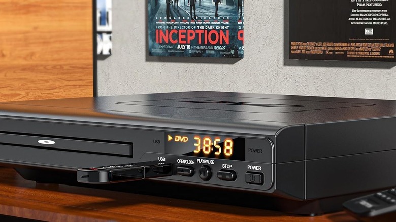 Lecteur DVD sur table avec l'affiche du film Inception en arrière-plan