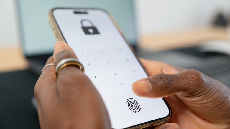Une personne déverrouillant son smartphone, avec l'option d'empreinte digitale ou de code PIN