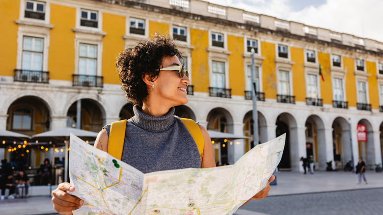 Un touriste souriant tient une carte