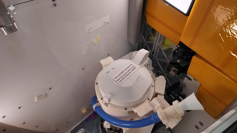 Jeremy Hansen, spécialiste de la mission Artemis II de l'Agence spatiale canadienne, présente une maquette du système universel de gestion des déchets d'Orion.