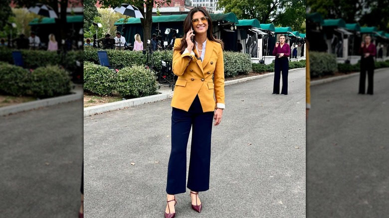 Kaitlan Collins sourit en parlant au téléphone à l'extérieur