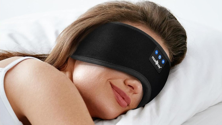 Une femme dort avec des écouteurs Musicozy