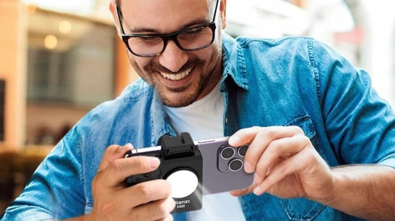 Un homme utilise le Ulanzi Bluetooth Smartphone Cap Grip sur son iPhone pour prendre des photos
