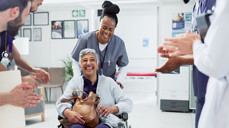 Patient en fauteuil roulant sortant d'un hôpital