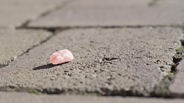 Morceau de gomme rose dépensé sur le trottoir
